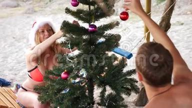 两个戴着圣诞帽的男人<strong>和女孩</strong>在海滩上迎接新年<strong>和</strong>圣诞节。 把<strong>圣诞树</strong>装饰在<strong>圣诞树</strong>上